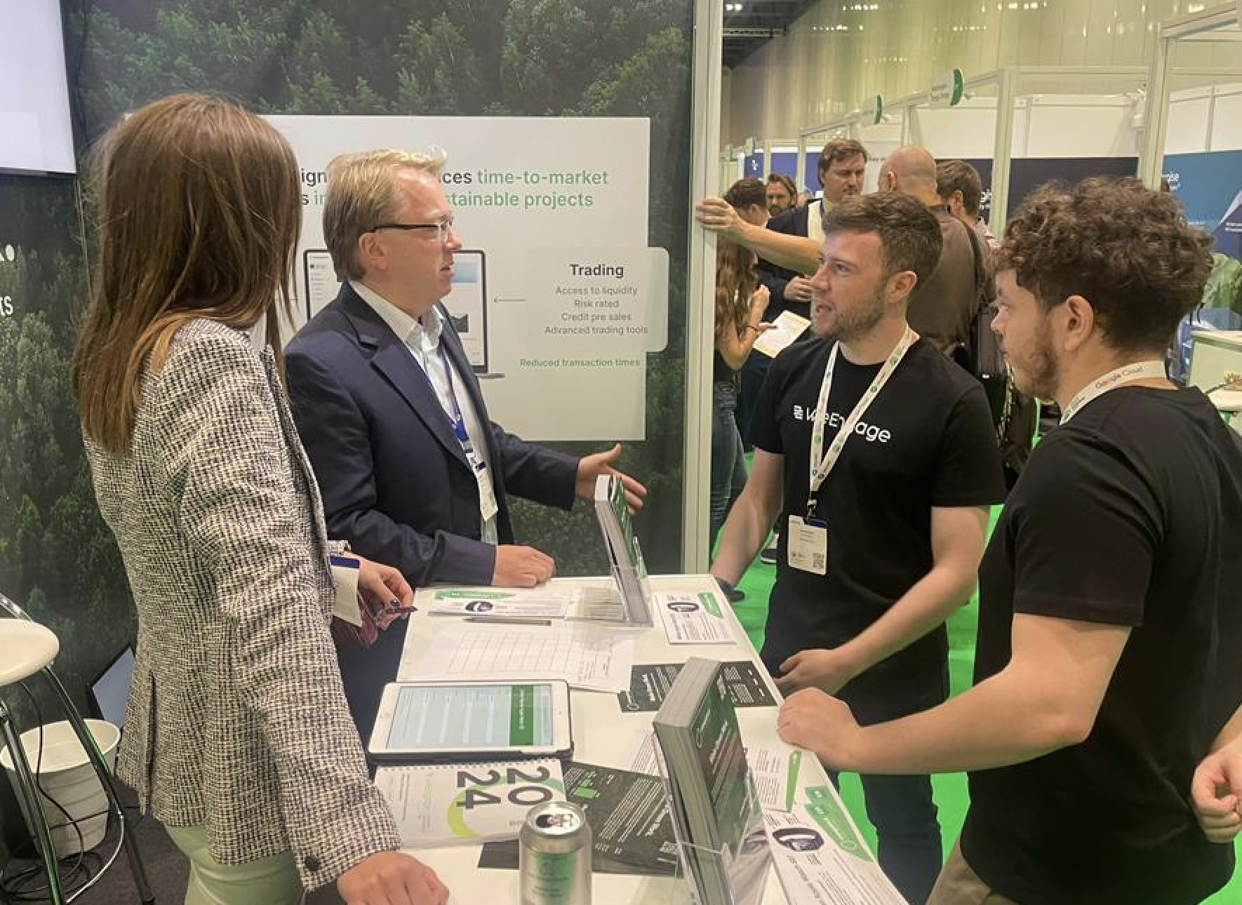 Changeblock team at a conference booth discussing environmental solutions with visitors
